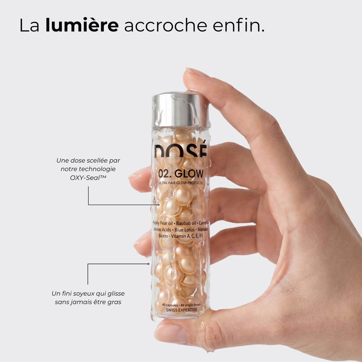 Flacon DOSE.02 GLOW en main — la lumière accroche enfin, dose scellée OXY-Seal™, fini soyeux sans effet gras